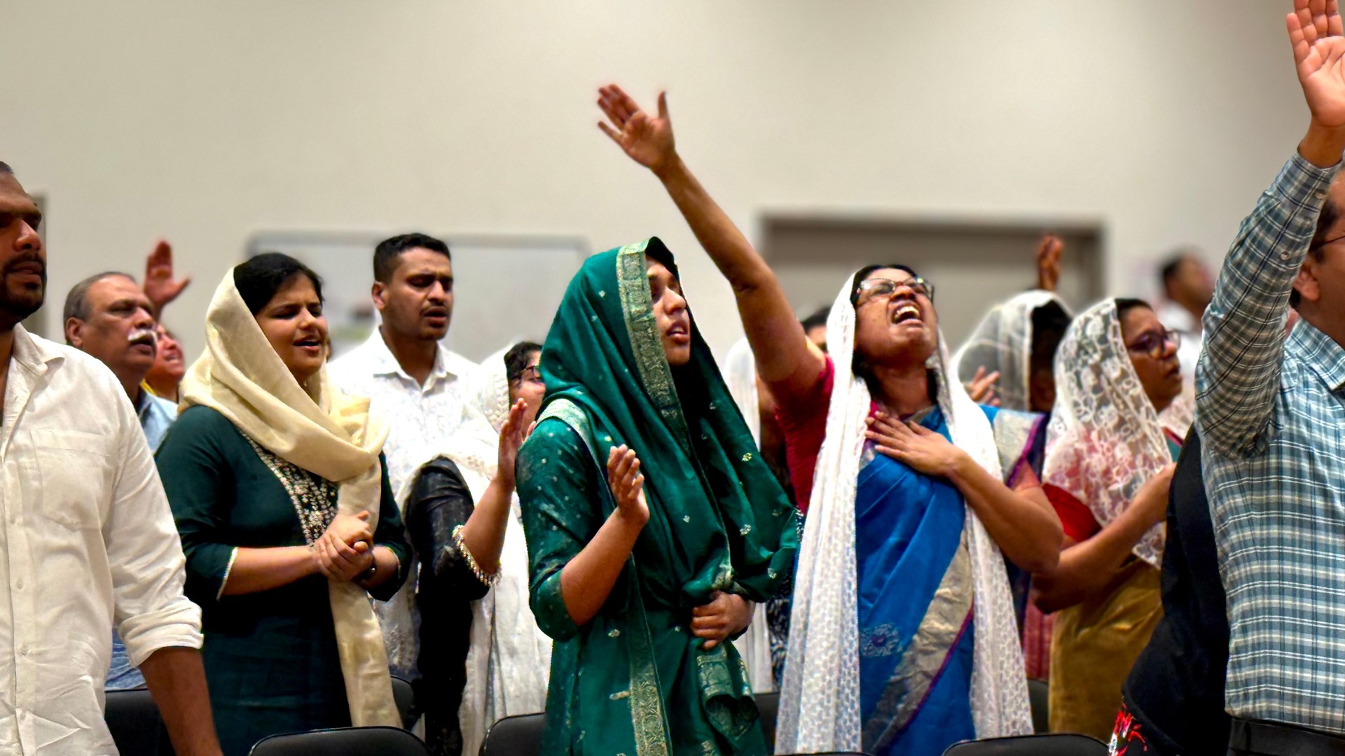 Congregation worshipping together with hands raised